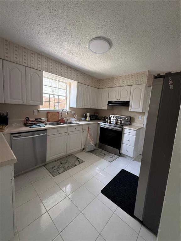 3757 Mimosa Ct, New Orleans, LA 70131 - kitchen featuring appliances with stainless steel finishes, a textured ceiling, under cabinet range hood, light countertops, and white cabinetry