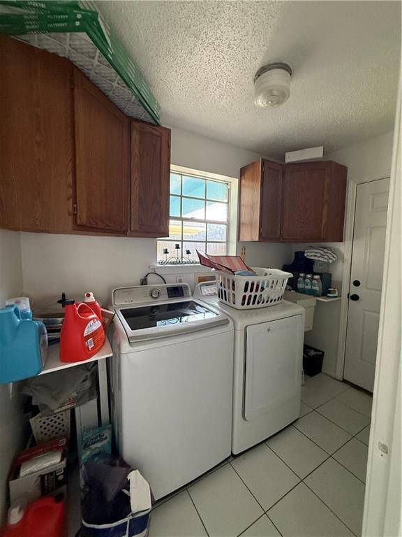 3757 Mimosa Ct, New Orleans, LA 70131 - laundry room with cabinet space, washer and dryer, a textured ceiling, and light tile patterned floors