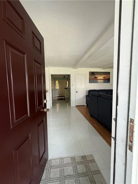 3757 Mimosa Ct, New Orleans, LA 70131 - foyer entrance featuring a textured ceiling and light tile patterned floors