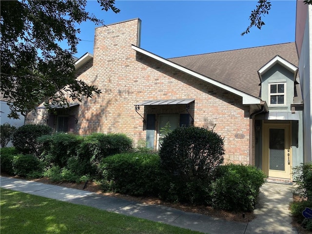 11110 Boardwalk Dr Unit 41, Baton Rouge, LA 70816 - view of side of property featuring brick siding, a chimney, and a shingled roof