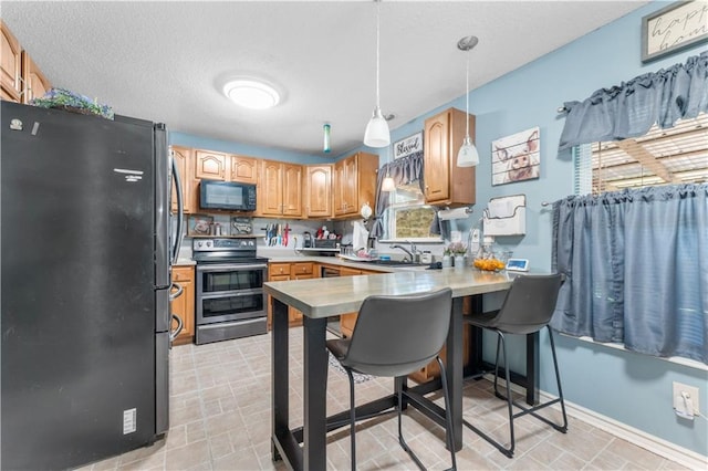1799 Kings Row, Slidell, LA 70461 - kitchen with black appliances, a peninsula, light countertops, pendant lighting, and a textured ceiling