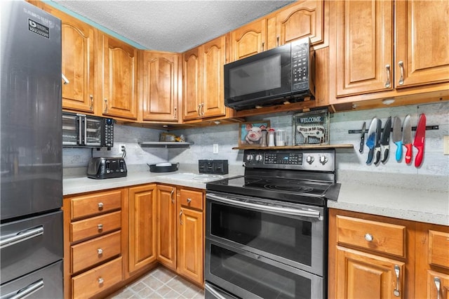 1799 Kings Row, Slidell, LA 70461 - kitchen with appliances with stainless steel finishes, light countertops, decorative backsplash, a textured ceiling, and brown cabinetry
