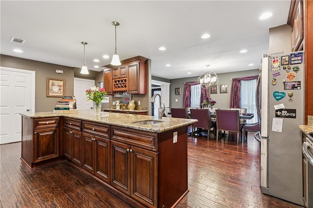 6744 Canal Blvd, New Orleans, LA 70124 - kitchen featuring freestanding refrigerator, dark wood-style flooring, a kitchen island, a chandelier, and recessed lighting