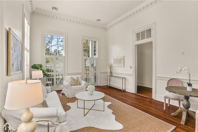 3325 Coliseum St, New Orleans, LA 70115 - living area featuring wood finished floors, crown molding, a decorative wall, and a wainscoted wall