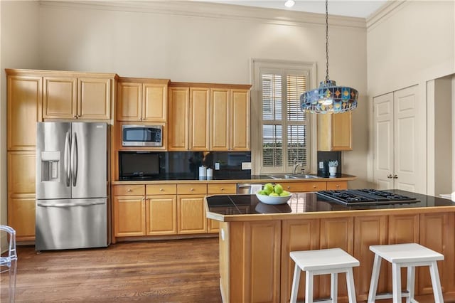 3325 Coliseum St, New Orleans, LA 70115 - kitchen with appliances with stainless steel finishes, crown molding, dark wood finished floors, a breakfast bar area, and a center island