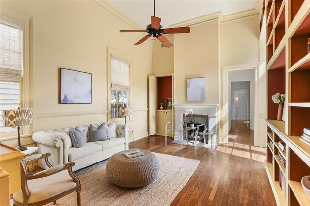3325 Coliseum St, New Orleans, LA 70115 - living area with wood finished floors, ceiling fan, a high ceiling, and ornamental molding