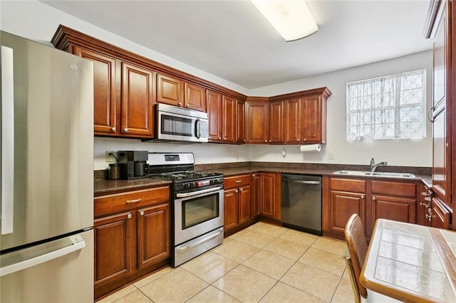 2517 Myrtle St, New Orleans, LA 70122 - kitchen with appliances with stainless steel finishes, light tile patterned flooring, dark countertops, and brown cabinets