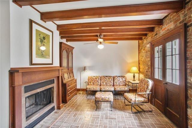1124 Barracks St, New Orleans, LA 70116 - living room featuring brick patterned floors, a fireplace, a ceiling fan, and beam ceiling