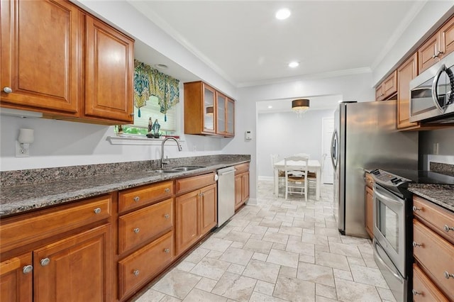 4400 Cleveland Pl, Metairie, LA 70003 - kitchen featuring appliances with stainless steel finishes, brown cabinets, stone tile floors, ornamental molding, and dark stone countertops