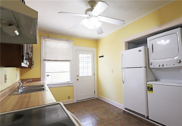 30507 Labarre Dr, Metairie, LA 70001 - kitchen with freestanding refrigerator, stacked washer and clothes dryer, a ceiling fan, light countertops, and crown molding