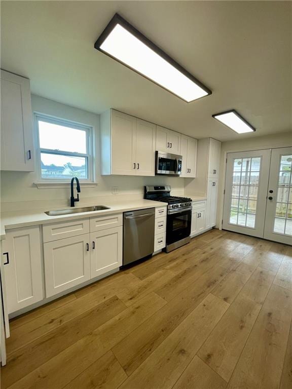 144 Yvonne Dr, Avondale, LA 70094 - kitchen featuring stainless steel appliances, white cabinets, plenty of natural light, and light wood-style flooring