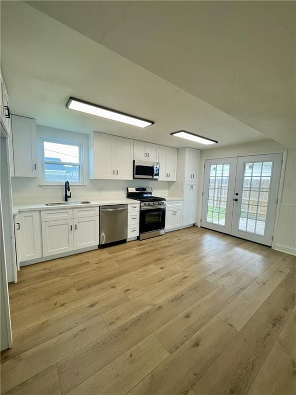 144 Yvonne Dr, Avondale, LA 70094 - kitchen featuring appliances with stainless steel finishes, light wood-type flooring, white cabinetry, and light countertops