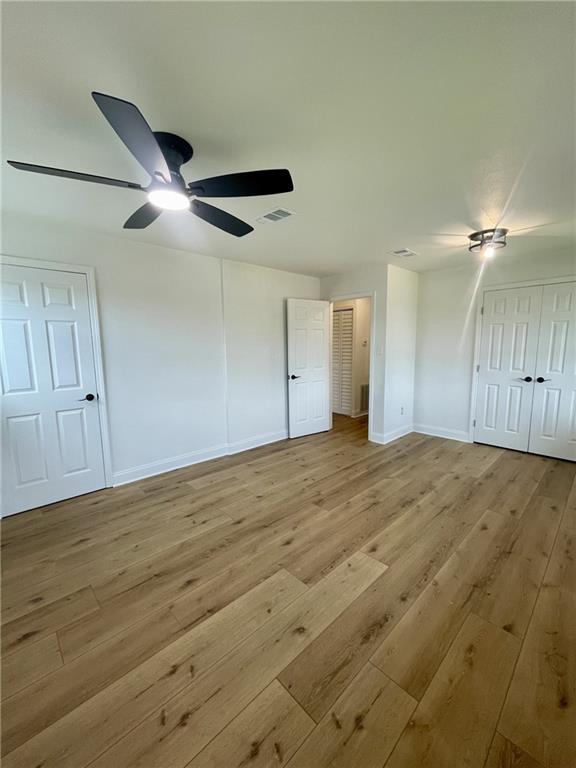 144 Yvonne Dr, Avondale, LA 70094 - unfurnished bedroom featuring wood-type flooring and a ceiling fan