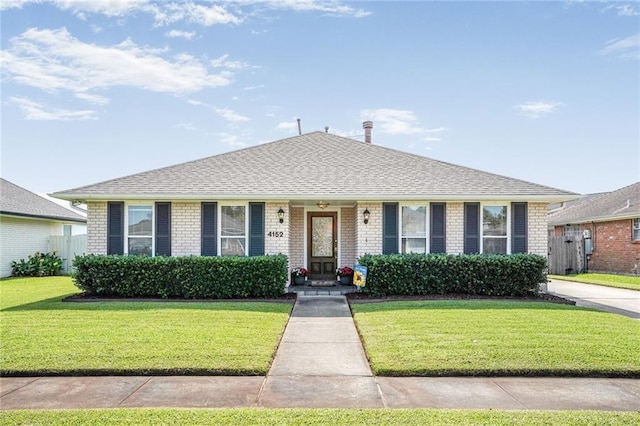4152 Cognac Dr, Kenner, LA 70065 - view of front of home with brick siding, a front yard, and a shingled roof