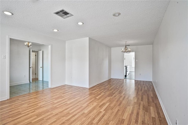 4152 Cognac Dr, Kenner, LA 70065 - empty room with a chandelier, wood finished floors, and a textured ceiling