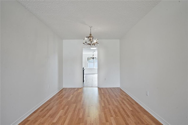 4152 Cognac Dr, Kenner, LA 70065 - unfurnished room featuring a chandelier, light wood finished floors, and a textured ceiling