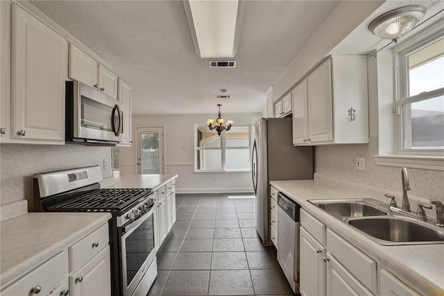 4152 Cognac Dr, Kenner, LA 70065 - kitchen featuring stainless steel appliances, plenty of natural light, white cabinets, and a textured ceiling