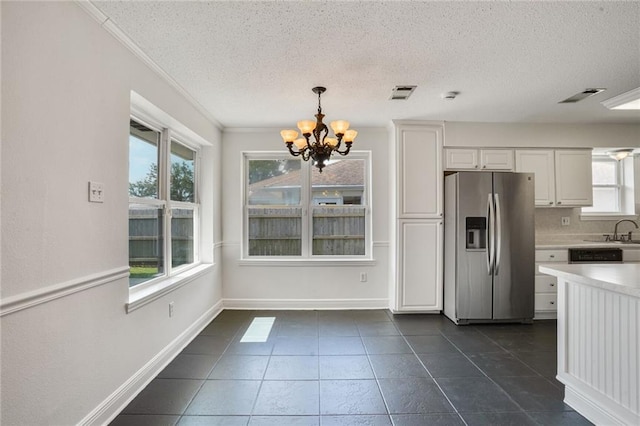 4152 Cognac Dr, Kenner, LA 70065 - kitchen featuring stainless steel fridge with ice dispenser, a chandelier, a textured ceiling, light countertops, and white cabinetry