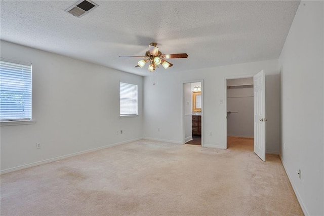 4152 Cognac Dr, Kenner, LA 70065 - unfurnished bedroom with a spacious closet, light carpet, a textured ceiling, a ceiling fan, and ensuite bath