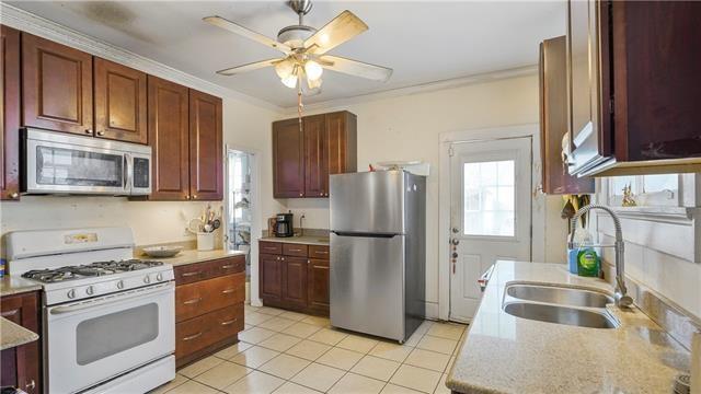 4429-31 Eden Ln, New Orleans, LA 70125 - kitchen with appliances with stainless steel finishes, ceiling fan, ornamental molding, and light tile patterned floors