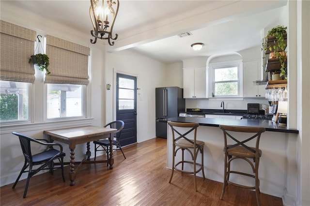 4717 Orleans Blvd, Jefferson, LA 70121 - kitchen with freestanding refrigerator, dark countertops, a peninsula, dark wood-type flooring, and white cabinetry