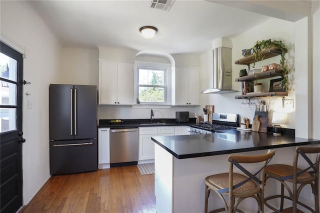 4717 Orleans Blvd, Jefferson, LA 70121 - kitchen with stainless steel appliances, plenty of natural light, wall chimney exhaust hood, and a peninsula