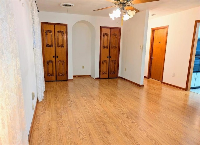 1116 Carnation Ave, Metairie, LA 70001 - empty room with arched walkways, light wood finished floors, and ceiling fan