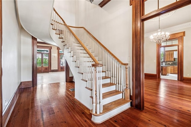 52 Tokalon Pl, Metairie, LA 70001 - stairway with wood-type flooring, a chandelier, a high ceiling, and ornamental molding