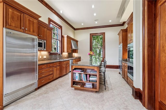 52 Tokalon Pl, Metairie, LA 70001 - kitchen with built in appliances, ornamental molding, backsplash, plenty of natural light, and light tile patterned flooring