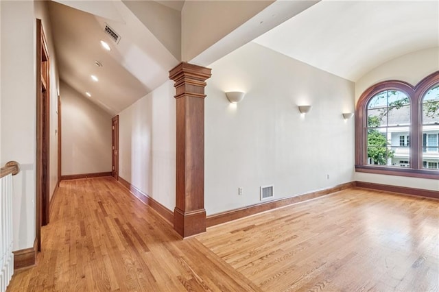 52 Tokalon Pl, Metairie, LA 70001 - spare room with vaulted ceiling, ornate columns, and light wood finished floors