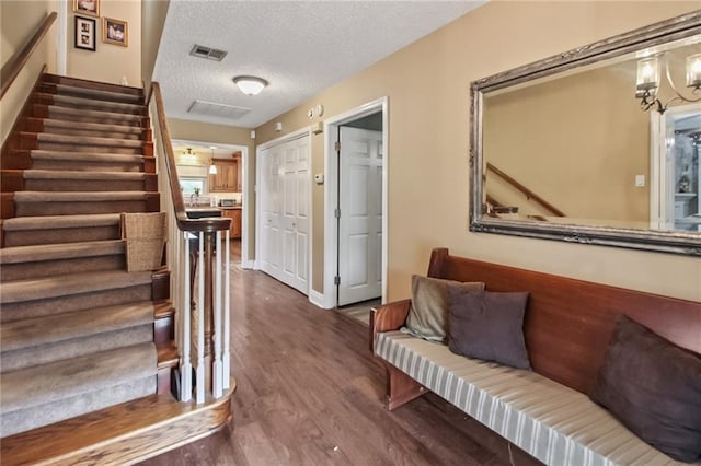 4969 Tasha Ln, Jean Lafitte, LA 70067 - stairway with wood finished floors, a textured ceiling, and a chandelier