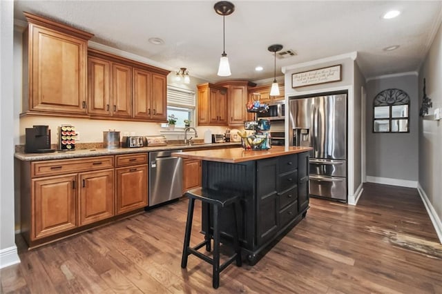 4969 Tasha Ln, Jean Lafitte, LA 70067 - kitchen with appliances with stainless steel finishes, brown cabinets, dark wood-type flooring, a center island, and recessed lighting