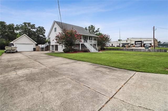 4969 Tasha Ln, Jean Lafitte, LA 70067 - view of front facade featuring stairs, a detached garage, a front yard, covered porch, and an outdoor structure