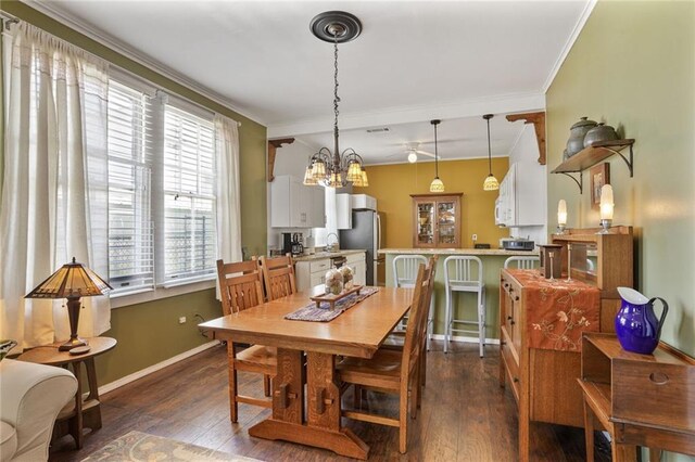 1717 Painters St, New Orleans, LA 70117 - dining area featuring a chandelier, dark wood-style flooring, and ornamental molding