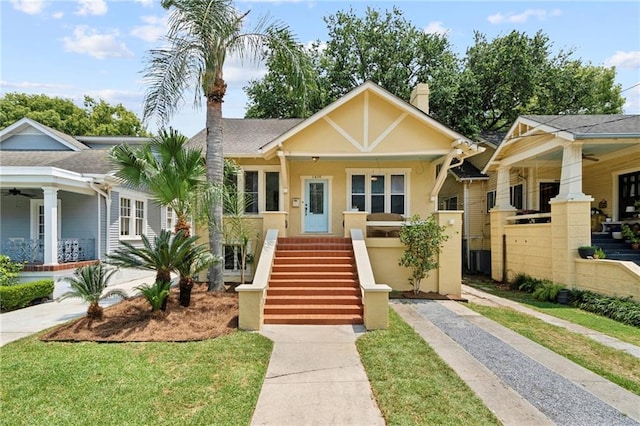 1419 Pine St, New Orleans, LA 70118 - view of front of home with a chimney, a porch, a ceiling fan, and stucco siding