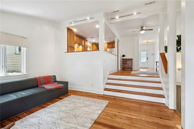 1419 Pine St, New Orleans, LA 70118 - living room featuring ceiling fan, stairway, and light wood-type flooring