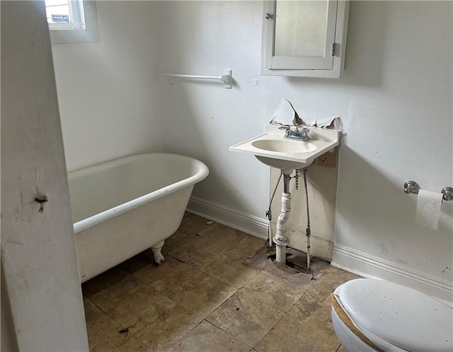 5827 Tchoupitoulas St, New Orleans, LA 70115 - bathroom with a freestanding bath and baseboards
