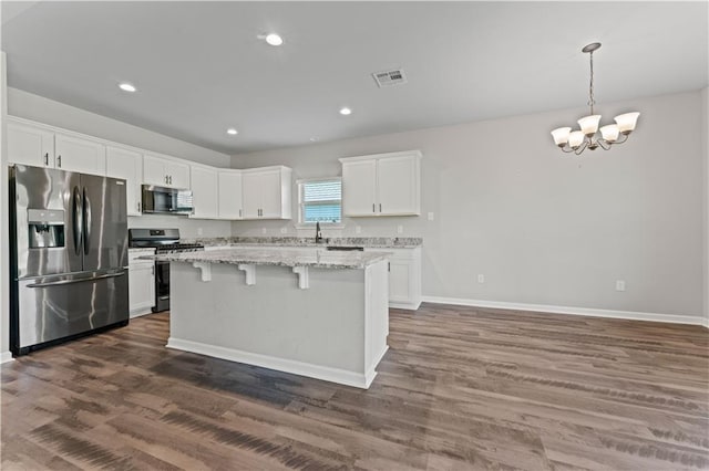 42333 Jasper Ln, Ponchatoula, LA 70454 - kitchen with appliances with stainless steel finishes, a kitchen island, white cabinets, dark wood-style flooring, and a chandelier