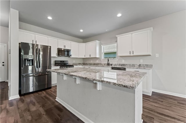 42333 Jasper Ln, Ponchatoula, LA 70454 - kitchen featuring appliances with stainless steel finishes, a kitchen island, white cabinetry, dark wood-style flooring, and recessed lighting