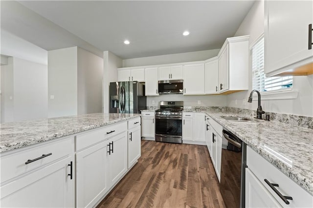 42333 Jasper Ln, Ponchatoula, LA 70454 - kitchen with appliances with stainless steel finishes, dark wood-style flooring, white cabinets, light stone counters, and recessed lighting