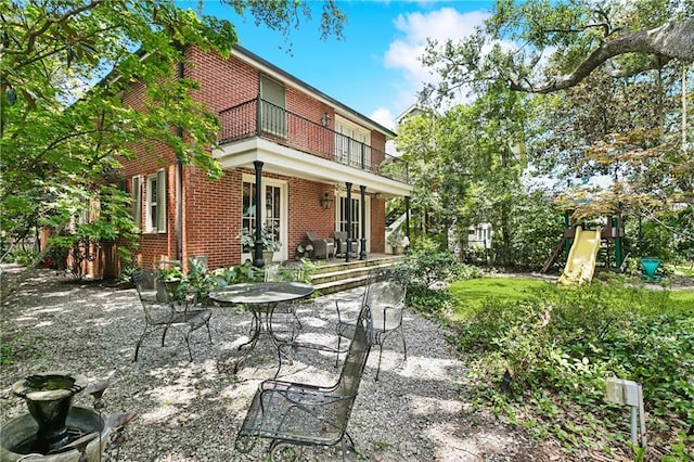 42 Crane St, New Orleans, LA 70124 - rear view of property featuring brick siding, a balcony, and a patio