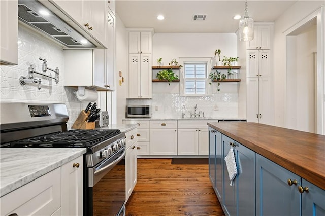 110 Atlantic Ave, New Orleans, LA 70114 - kitchen featuring appliances with stainless steel finishes, ventilation hood, butcher block countertops, open shelves, and white cabinets