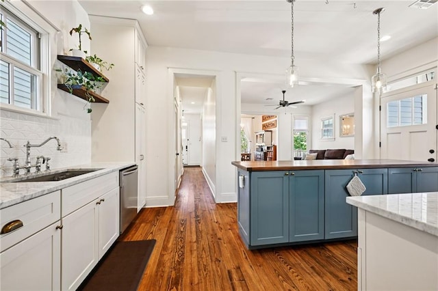 110 Atlantic Ave, New Orleans, LA 70114 - kitchen with tasteful backsplash, blue cabinetry, dishwasher, dark wood-style flooring, and hanging light fixtures