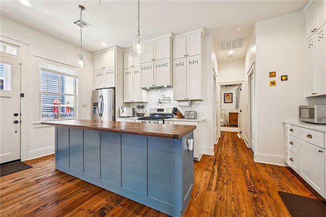 110 Atlantic Ave, New Orleans, LA 70114 - kitchen with butcher block counters, appliances with stainless steel finishes, dark wood-style floors, white cabinets, and recessed lighting