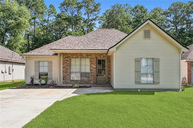 739 Chevreuil St, Mandeville, LA 70448 - view of front of home with a front yard, a shingled roof, and brick siding