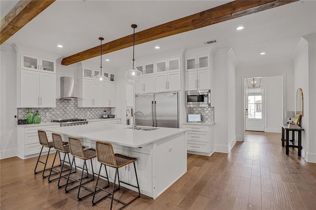 6818 Louisville St, New Orleans, LA 70124 - kitchen with built in appliances, wall chimney range hood, beam ceiling, an island with sink, and backsplash