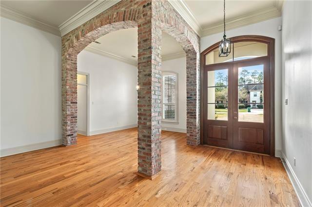 117 Grande Maison Blvd, Mandeville, LA 70471 - foyer entrance with arched walkways, french doors, wood finished floors, ornamental molding, and ornate columns