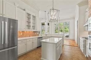 117 Grande Maison Blvd, Mandeville, LA 70471 - kitchen with stainless steel appliances, a chandelier, a kitchen island, glass insert cabinets, and light countertops