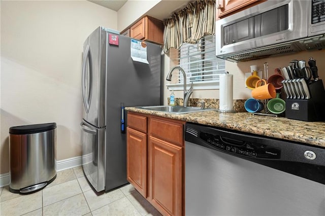 3805 Houma Blvd Unit C210, Metairie, LA 70006 - kitchen with stainless steel appliances, brown cabinets, light stone countertops, and light tile patterned floors