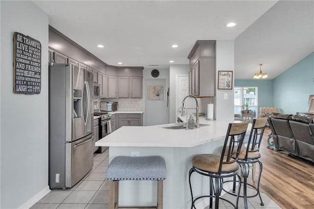 497 Jj Ln, Covington, LA 70433 - kitchen with stainless steel appliances, gray cabinets, a peninsula, open floor plan, and decorative backsplash